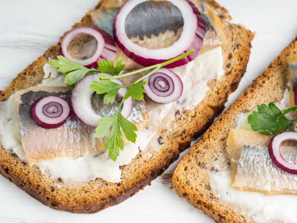 Daenisches Smorrebrod mit gesalzenem Hering, roter Zwiebel und Butter