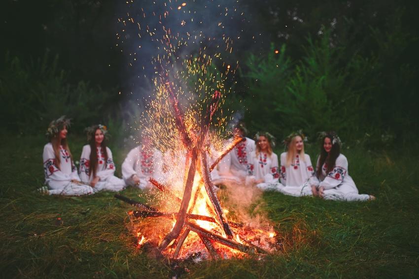 Gruppe junger Damen in traditioneller Kleidung vor einem Mitsommer Feuer - Mitternachtssonne 