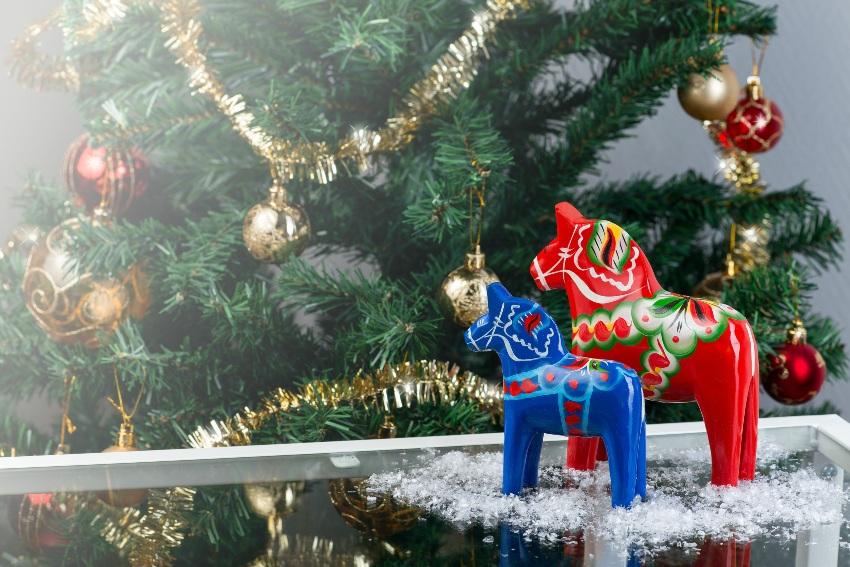 Dalapferde in Rot und Blau vor dem Weihnachtsbaum