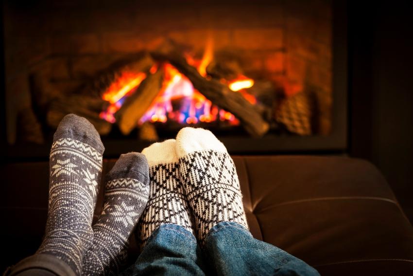 Füße mit bunten Socken vor dem Kamin